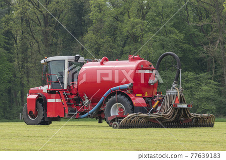 Injecting a freshly mowed lawn with a red injector . 77639183