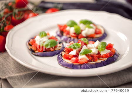 Baked eggplant with parmesan cheese, tomatoes and basil 77640059