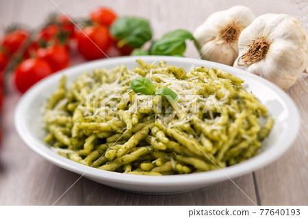 Pasta with pesto sauce and parmesan on a plate. Pasta with pesto sauce and parmesan on a plate. 77640193