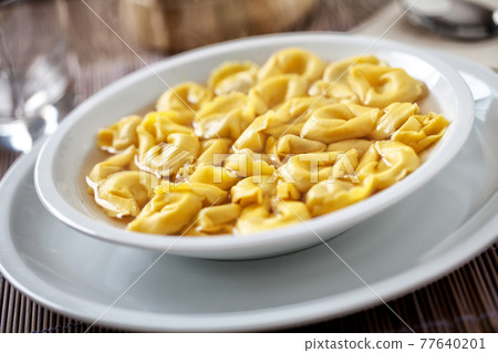 Italian Tortellini In broth on a plate. Italian Tortellini In broth on a plate. 77640201