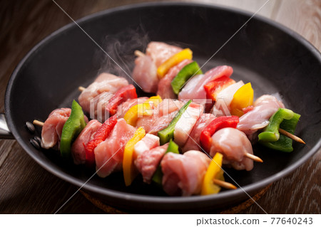 Chicken skewers cooking in a pan. High quality photo. Chicken skewers cooking in a pan. High quality photo. 77640243