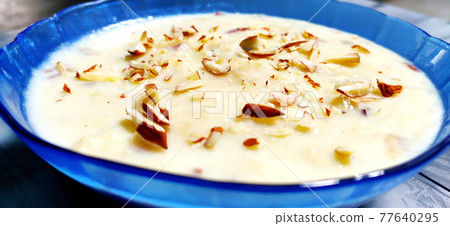 Sweet Rabdi or Lachha Rabri or basundi, made with pure milk garnished with dry fruits. Served in a bowl over moody background. 77640295
