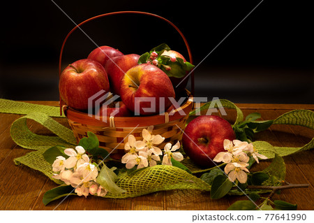 Fresh apples with apples blossoms on a dramatic dark wood background. Naturmort made from pears in a glass bowl. Fresh apples with apples blossoms on a dramatic dark wood background. Naturmort made from pears in a glass bowl. 77641990
