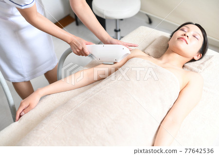 Young woman undergoing hair removal 77642536