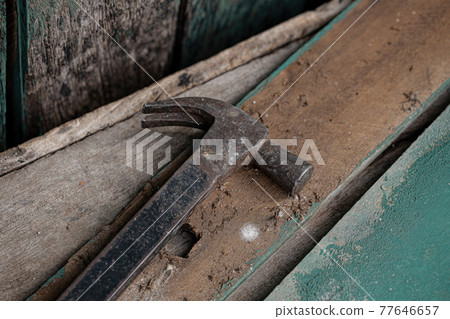 Metal hammer under dirty wooden surface Metal hammer under dirty wooden surface 77646657