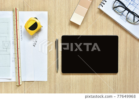 a top view of architect working desk with equipment for drawings pens sketched idea on wood table, the concept of modern technology for architectural working with tablet a top view of architect working desk with equipment for drawings pens sketched idea on wood table, the concept of modern technology for architectural working with tablet 77649968