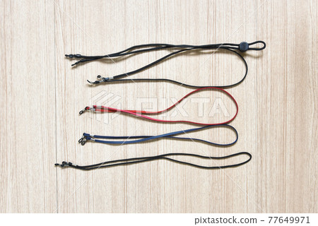 a various of eyeglasses strap accessory for glasses on a wooden background a various of eyeglasses strap accessory for glasses on a wooden background 77649971