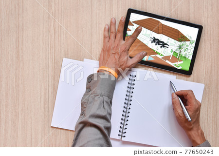 a tablet showing hand sketch of architectural drawing design detail with digital pens on wood table, the concept of new technology for working of tablet with digital pen 77650243