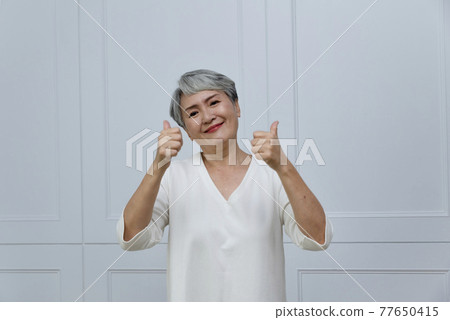 一位銀髮白髮的年長婦女在落地窗旁 77650415