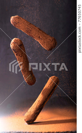 French dessert. Eclair with chocolate icing. Dark background French dessert. Eclair with chocolate icing. Dark background 77650745