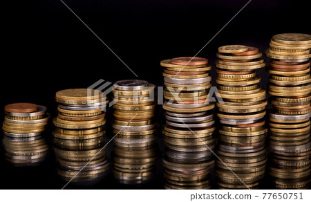 Stacks cf different country coins on black background Stacks cf different country coins on black background 77650751