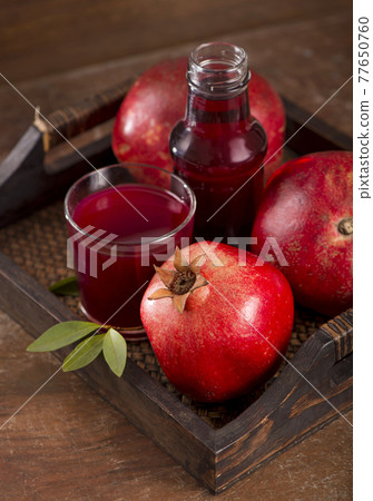 pomegranate juice and pomegranate fruit on wooden background pomegranate juice and pomegranate fruit on wooden background 77650760