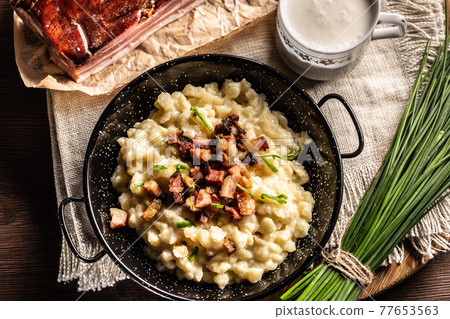 Top view of the gnocchi with cheese food halusky with sour milk and a bunch of chives Top view of the gnocchi with cheese food halusky with sour milk and a bunch of chives 77653563