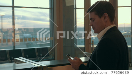 Young man typing sms in airport 77656689