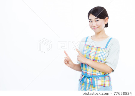 Housewife in her thirties pointing 77658824