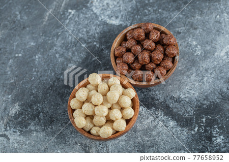 Wooden bowls with sweet corn balls on a gray background Wooden bowls with sweet corn balls on a gray background 77658952