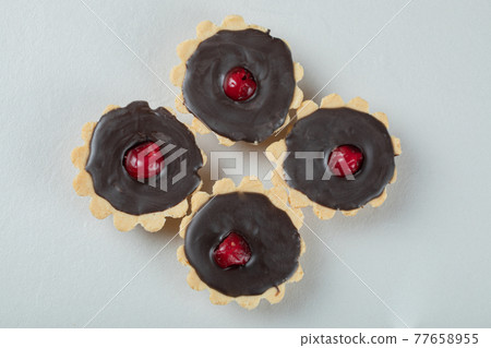 Chocolate tartalette with red cherry on the top 77658955