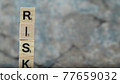 Risk writing with black letters on wooden dices on the marble background 77659032