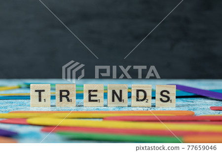 Trends writing with black letters on wooden dices on the blue background Trends writing with black letters on wooden dices on the blue background 77659046