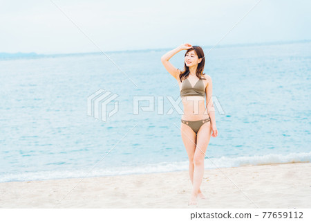 放鬆在海灘的泳裝的婦女 77659112