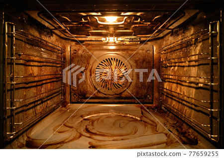 Dirty oven from traces of food inside with the light on Dirty oven from traces of food inside with the light on 77659255