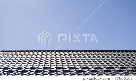 Brown corrugated metal profile roof installed on a modern house. The roof of corrugated sheet. Roofing of metal profile wavy shape. Modern roof made of metal. Metal roofing. Brown corrugated metal profile roof installed on a modern house. The roof of corrugated sheet. Roofing of metal profile wavy shape. Modern roof made of metal. Metal roofing. 77660105
