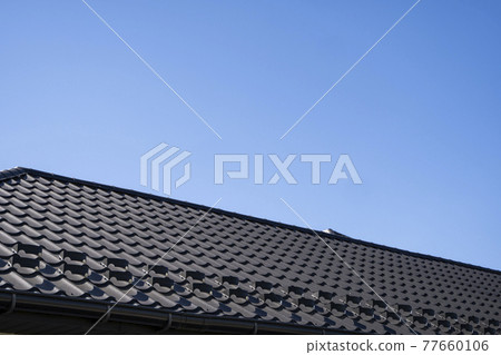 Brown corrugated metal profile roof installed on a modern house. The roof of corrugated sheet. Roofing of metal profile wavy shape. Modern roof made of metal. Metal roofing. Brown corrugated metal profile roof installed on a modern house. The roof of corrugated sheet. Roofing of metal profile wavy shape. Modern roof made of metal. Metal roofing. 77660106