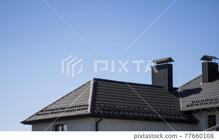 Brown corrugated metal profile roof installed on a modern house. The roof of corrugated sheet. Roofing of metal profile wavy shape. Modern roof made of metal. Metal roofing. Brown corrugated metal profile roof installed on a modern house. The roof of corrugated sheet. Roofing of metal profile wavy shape. Modern roof made of metal. Metal roofing. 77660108