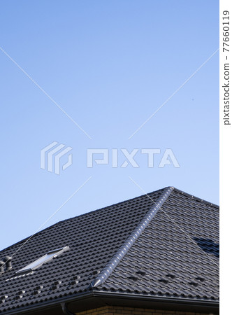 Brown corrugated metal profile roof installed on a modern house. The roof of corrugated sheet. Roofing of metal profile wavy shape. Modern roof made of metal. Metal roofing. Brown corrugated metal profile roof installed on a modern house. The roof of corrugated sheet. Roofing of metal profile wavy shape. Modern roof made of metal. Metal roofing. 77660119