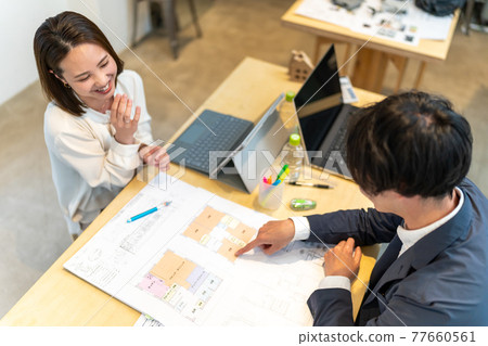 A female business scene explaining the floor plan of a house A female business scene explaining the floor plan of a house 77660561