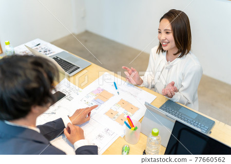 A female business scene explaining the floor plan of a house A female business scene explaining the floor plan of a house 77660562
