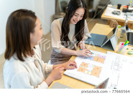 A female business scene explaining the floor plan of a house A female business scene explaining the floor plan of a house 77660564