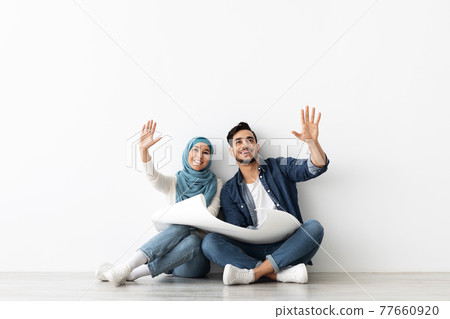 Loving muslim couple thinking about design in new house 77660920
