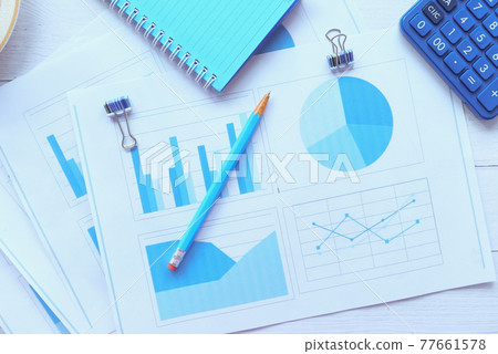 financial graph, calculator and notepad on table  77661578