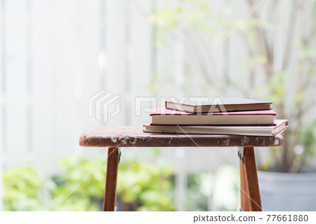 窗邊木製梯子上堆放著一本破舊的書 77661880