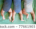 Newborn triplets boys lie on a stomach on a blanket 77661903