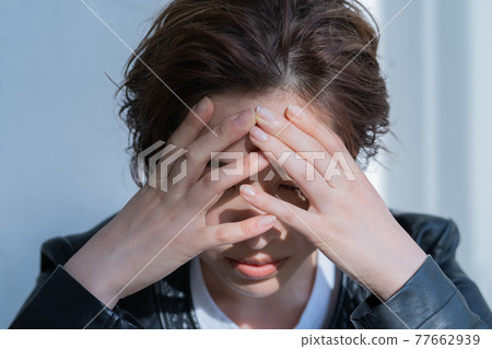 Genderless LGBT woman wearing a leather jacket that covers her face 77662939