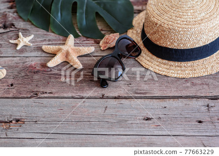 Beach accessories: glasses and hat with shells and sea stars on a colored background Beach accessories: glasses and hat with shells and sea stars on a colored background 77663229