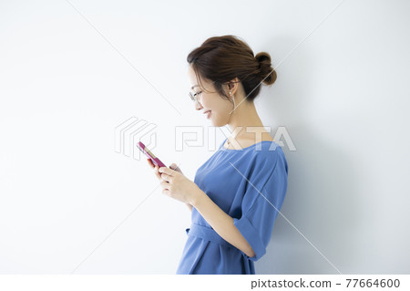 A woman watching a smartphone A woman watching a smartphone 77664600