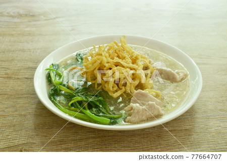crispy fried egg noodle with slice soft marinated pork and Chinese kale dressing gravy sauce on plate crispy fried egg noodle with slice soft marinated pork and Chinese kale dressing gravy sauce on plate 77664707