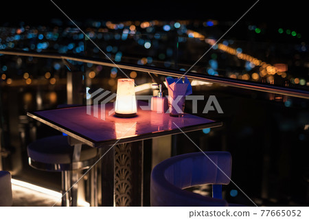 Rooftop table of pub and restaurant with cityscape view 77665052