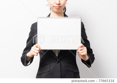 站在白色背景前，拿著寫生簿的女商人 77665318
