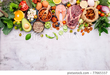 Ketogenic low carbs diet concept. Ingredients for healthy foods selection set up on white concrete background. Ketogenic low carbs diet concept. Ingredients for healthy foods selection set up on white concrete background. 77665337
