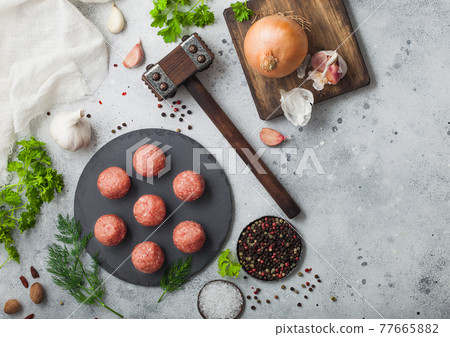 Fresh beef meatballs on stone board with pepper, salt and garlic on light background with dill 77665882
