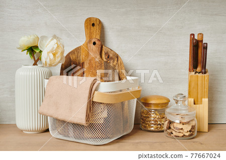 Two wooden chopping boards in a basket next to a vase of flowers Two wooden chopping boards in a basket next to a vase of flowers 77667024