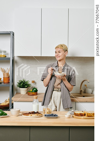 A person having breakfast in a kitchen A person having breakfast in a kitchen 77667048