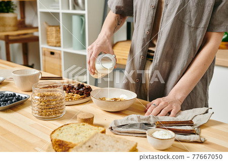 Woman preparing food on a table in the morning Woman preparing food on a table in the morning 77667050