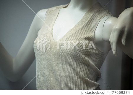 Closeup of beige tee-shirt on mannequin without bra in a fashion store showroom 77669274
