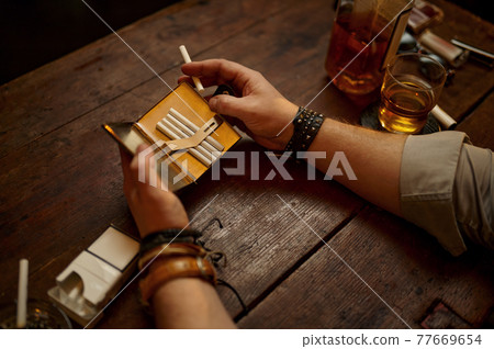 Serious man holds cigarette case Serious man holds cigarette case 77669654