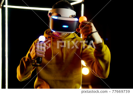 Young gamer plays in virtual reality headset 77669739
